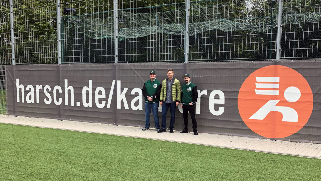 Gruppenfoto vor einem Sponsoren-Banner