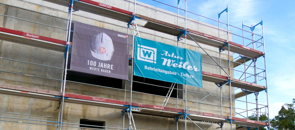 Rohbau mit Fassadengerüst und Bannern