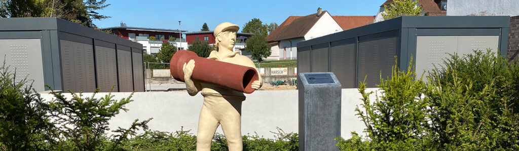 Skulptur einer arbeitenden Figur mit einem Steinzeugrohr