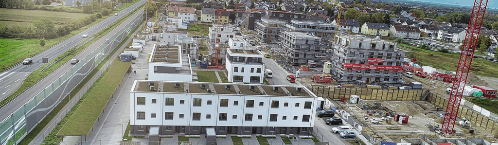 Luftaufnahme eines Wohnbauprojekts mit Reihen‑ und Mehrfamilienhäusern