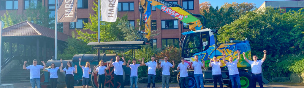 Gruppenfoto vor einem Bagger