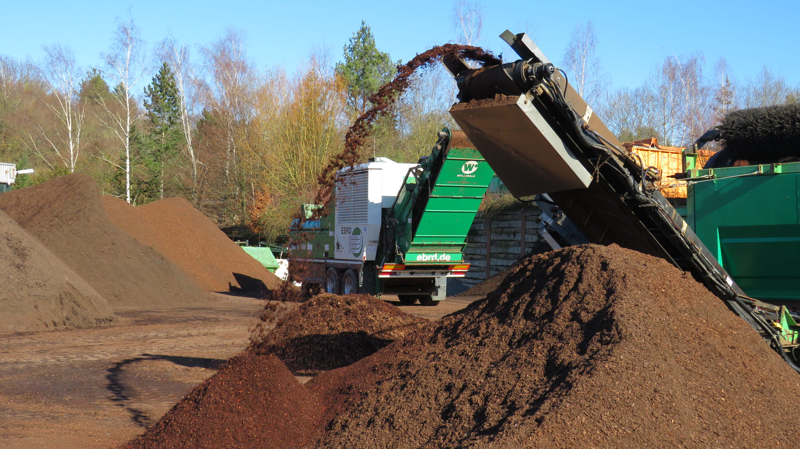 Materialaufbereitungsanlage mit Förderband zur Verarbeitung von Holzhackschnitzeln oder Kompostmaterial.