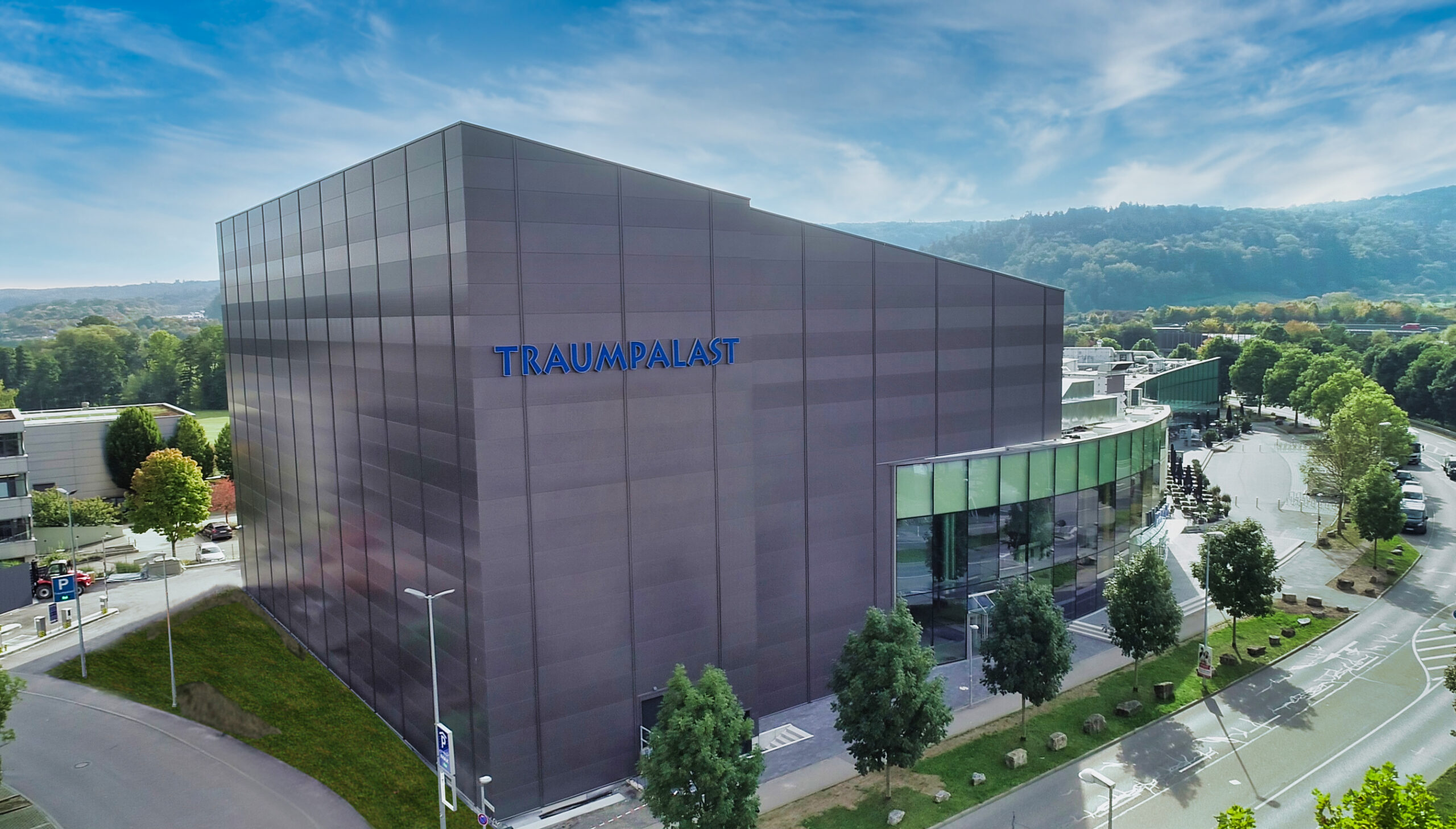 Großes Veranstaltungsgebäude „Traumpalast“ mit moderner Fassadenverkleidung in städtischer Umgebung.