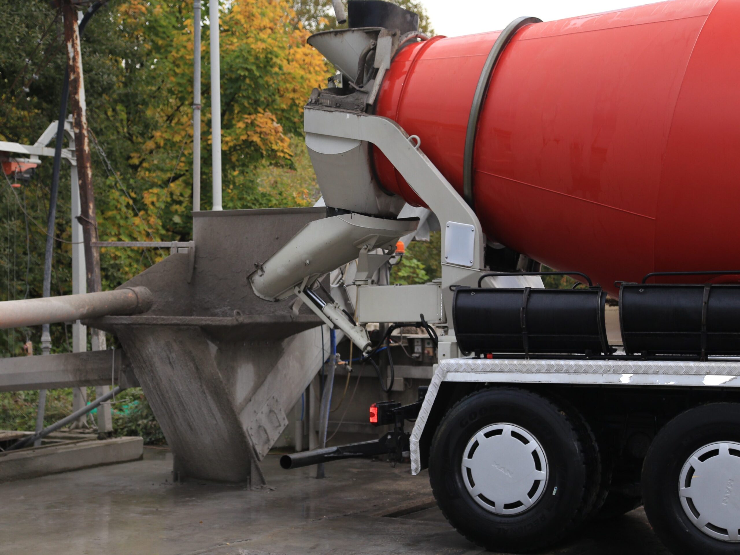 Betonmischer beim Entladen von Transportbeton in einen Aufgabetrichter.
