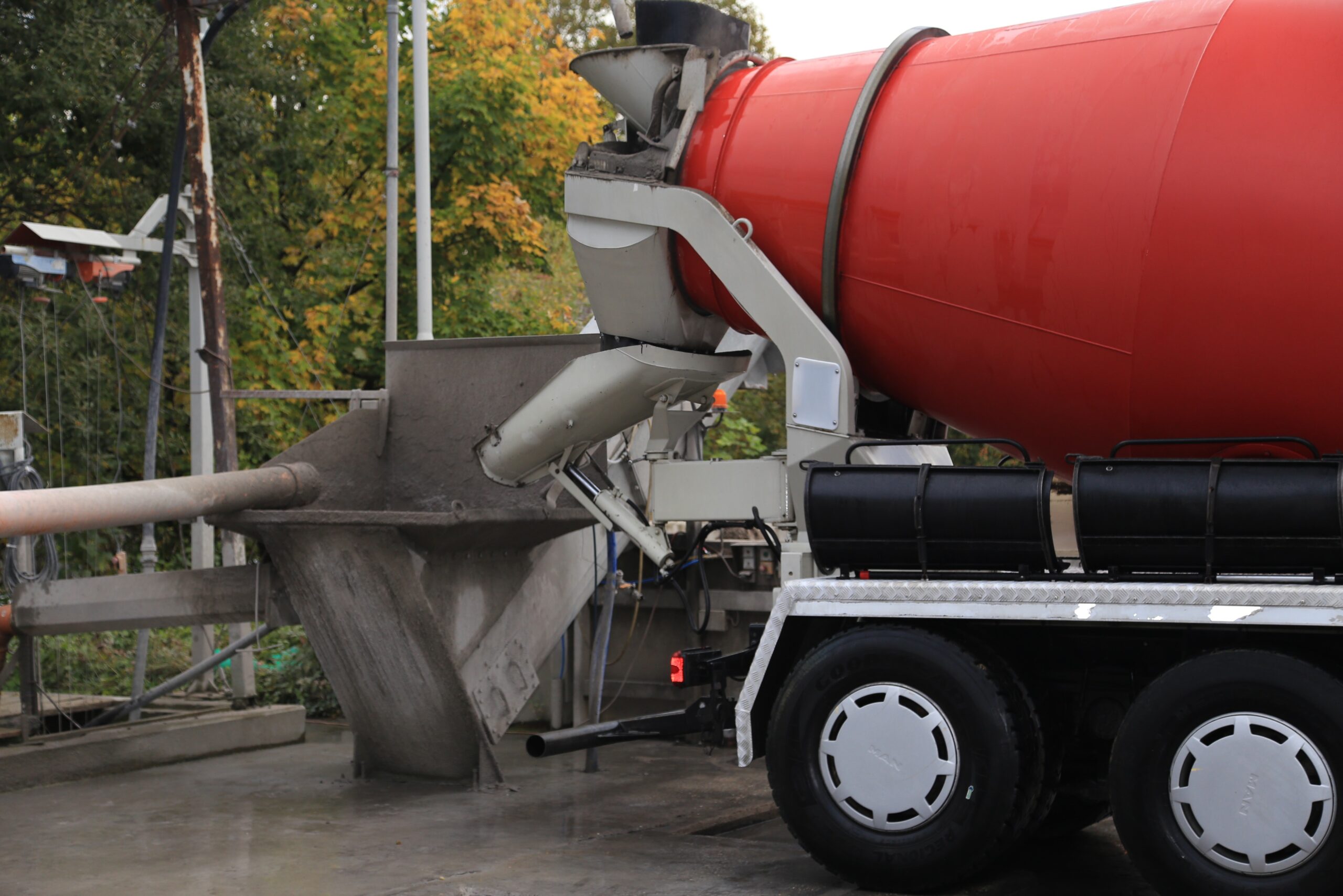 Betonmischer beim Entladen von Transportbeton in einen Aufgabetrichter.