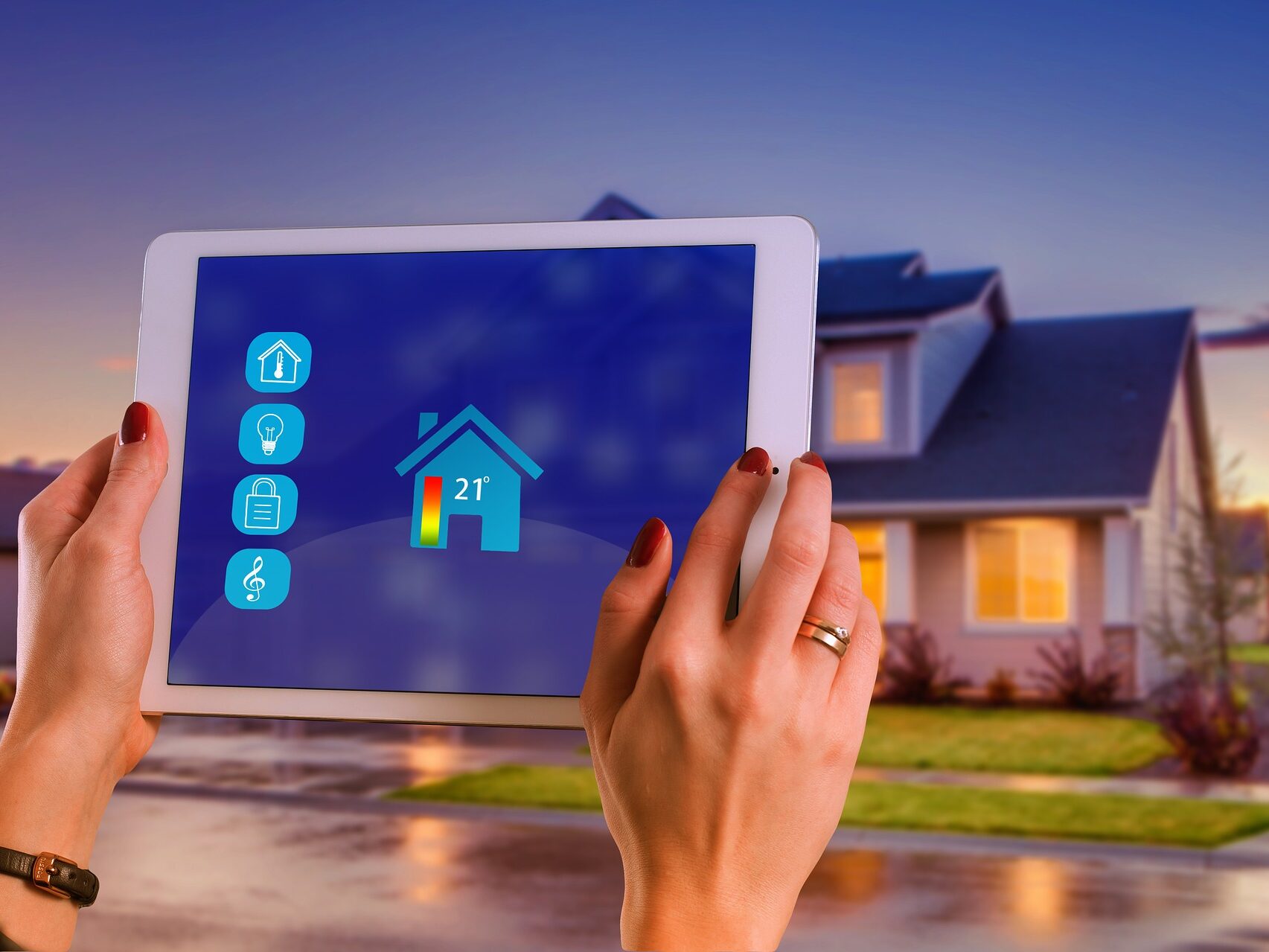 Tablet mit Smart‑Home‑Oberfläche zur Heizungssteuerung vor einem Einfamilienhaus.