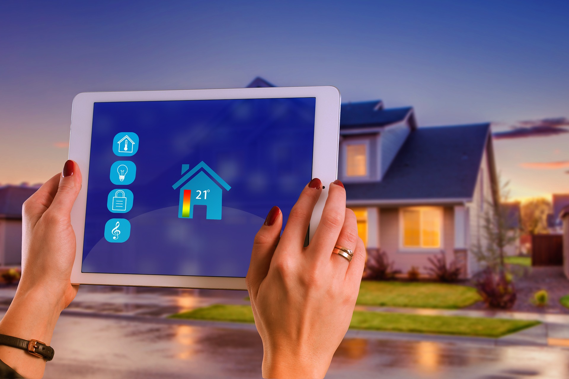 Tablet mit Smart‑Home‑Oberfläche zur Heizungssteuerung vor einem Einfamilienhaus.
